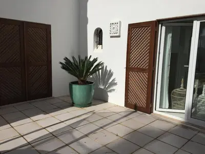 a porch with a potted plant next to a door at Vilamoura Villa Alegria in Vilamoura