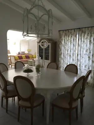 a dining table and chairs in a living room at Vilamoura Villa Alegria in Vilamoura