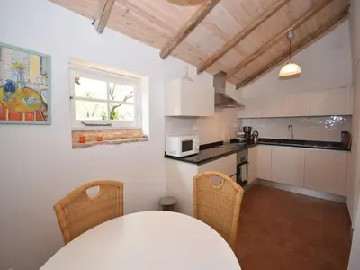 a kitchen with a table and chairs in a room at Elegant Loulé Mansion with Pool in Loulé