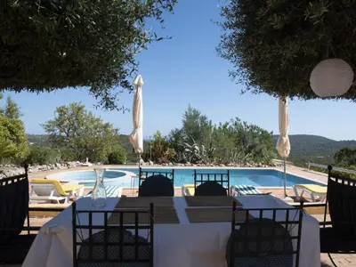 a table with chairs next to a swimming pool at Elegant Loulé Mansion with Pool in Loulé