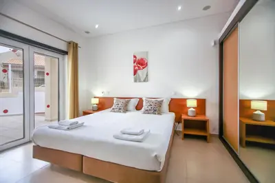 a bedroom with a large white bed and a balcony at Villa Rafaella II Palace by Atlantic Places in Albufeira