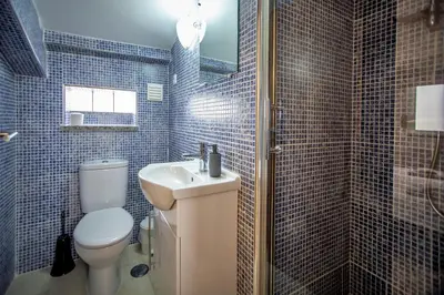 a blue tiled bathroom with a toilet and a sink at Villa Rafaella II Palace by Atlantic Places in Albufeira