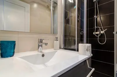 a bathroom with a white sink and a shower at Albufeira Oldtown 330ft Beach Parking AC Wifi in Albufeira