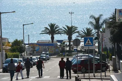 a group of people crossing a busy city street with cars at Sol Nascente Apartment in Albufeira