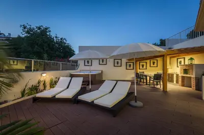 a deck with lounge chairs and umbrellas on a patio at D_Loft Sea and Golf in Albufeira