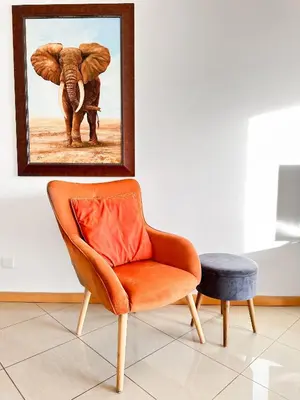 an orange chair next to a picture of an elephant at Luxury Apartment Ocean View by Be Cherish in Páteo