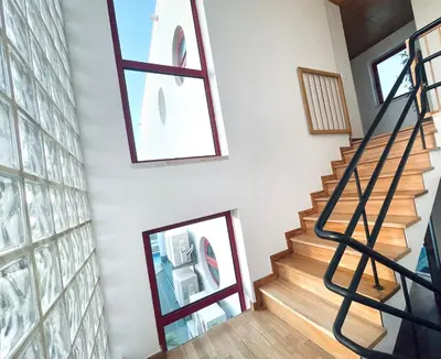 a staircase in a house with two windows and a mirror at Vila D'Alba - Sem Stress in Albufeira