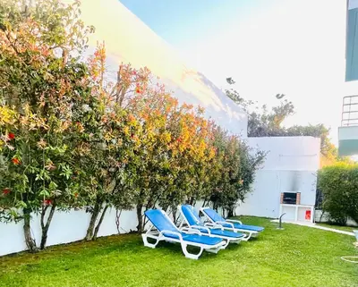 a row of blue chairs sitting in the grass at Vila D'Alba - Sem Stress in Albufeira