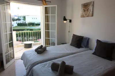 two beds in a room with a balcony at Villa Summertime - Private Jacuzzi and bikes, beach 800m in Albufeira