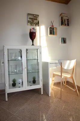 a white cabinet with glass shelves and a chair at Villa Summertime - Private Jacuzzi and bikes, beach 800m in Albufeira
