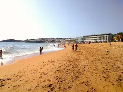 a group of people walking on a beach at Vista Mar Apartamento in Albufeira
