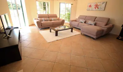 a living room with two couches and a coffee table at Villa Fonte Santa in Quarteira