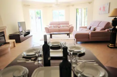 a living room with a table with wine glasses at Villa Fonte Santa in Quarteira