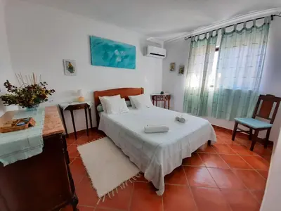 a bedroom with a bed and a table and a chair at Villa Quinta do Algarve in Albufeira