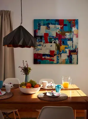 a dining room table with a painting on the wall at Apartment Orada Marina in Albufeira