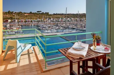 a balcony with a table and a view of a marina at Apartment Orada Marina in Albufeira