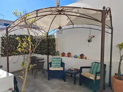 a patio with two chairs and an umbrella at The Sunny Cottage by Freetimealgarve in Faro
