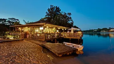 a restaurant on a dock on the water at night at Blue&Greens Apartment in Quinta do Lago