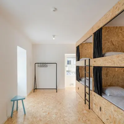 a room with two bunk beds and a mirror at Hostel Conii & Suites Algarve in Quarteira