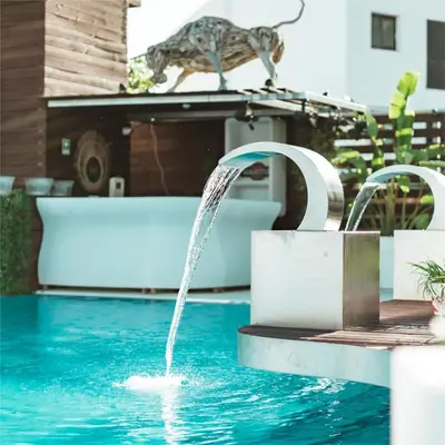a water fountain in the middle of a swimming pool at Apartamentos Honorio - Pool and Garden in Vilamoura