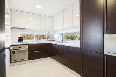 a kitchen with brown cabinets and stainless steel appliances at Laguna - Vilamoura in Vilamoura