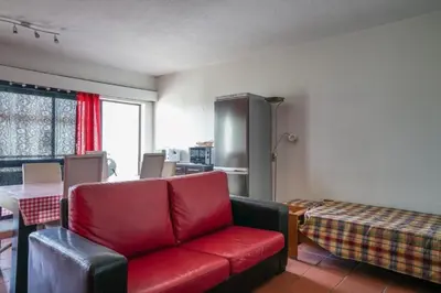 a living room with a red couch and a table at Akisol Vilamoura Star II in Quarteira