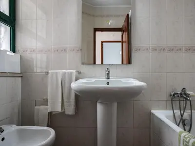a bathroom with a sink and a toilet and a mirror at Akisol Quarteira Relax III in Quarteira