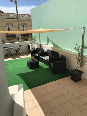 a patio with two couches and an umbrella at MariaHouse in Faro