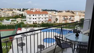 a balcony with a table and chairs and a pool at Vista das Ondas Apartamento 205 B2 - Olhos de Agua in Albufeira