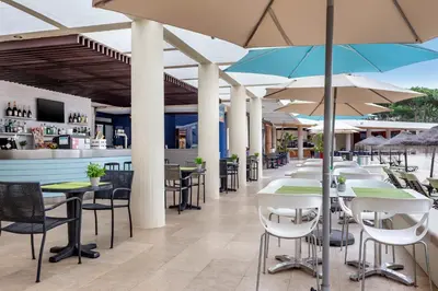 a restaurant with tables and chairs with umbrellas at Vilar do Golf in Quinta do Lago