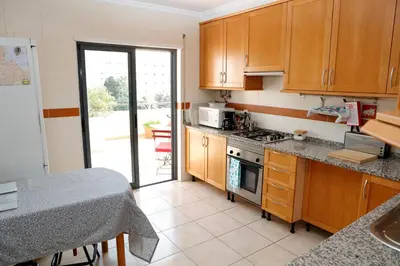 a kitchen with wooden cabinets and a stove top oven at BellaVita City Faro in Faro