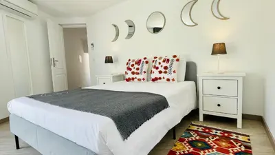 a white bedroom with a large bed and two night stands at Strip by Check-in Portugal in Albufeira