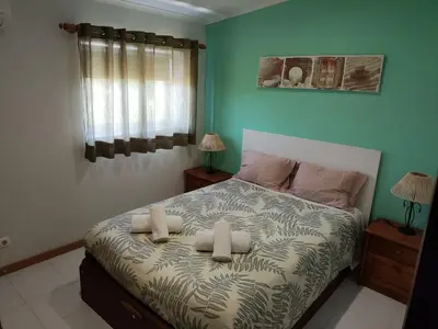 a bedroom with a bed with two towels on it at Casa Azul in Albufeira