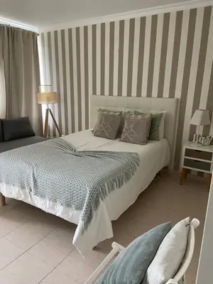 a bedroom with a bed and a striped wall at Moura 11 in Vilamoura