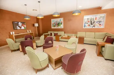 a waiting room with couches and tables and chairs at Vilamoura Garden Hotel in Vilamoura