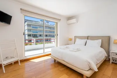 a bedroom with a large bed and a large window at Marina Vilamoura Triplex in Vilamoura