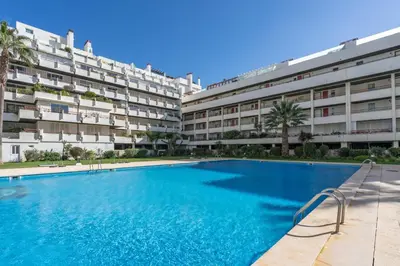 a swimming pool in front of a building at Marina Vilamoura Triplex in Vilamoura