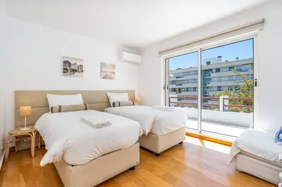 two beds in a room with a large window at Marina Vilamoura Triplex in Vilamoura