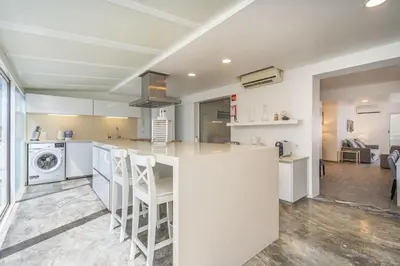 a kitchen with white cabinets and a washer and dryer at Marina Vilamoura Triplex in Vilamoura