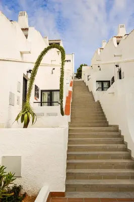 a stairway leading up to a white building with a plant at 3HB Golden Beach in Albufeira