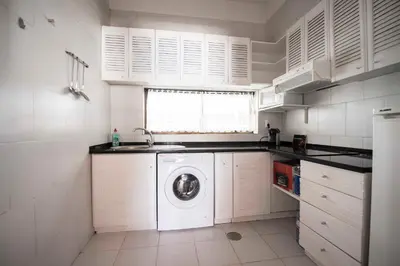 a kitchen with a washing machine and a sink at Apartamentos Tio Papel in Albufeira
