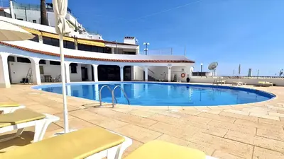 a large swimming pool in front of a building at Apartamentos Tio Papel in Albufeira