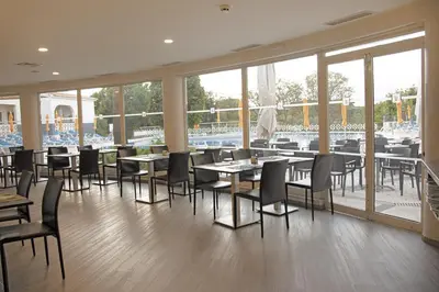 a restaurant with tables and chairs and a view of the water at Luna Miramar Club in Albufeira