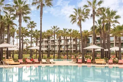 a bed with a lamp and a pillow on it at Kimpton Atlantico Algarve by IHG in Albufeira