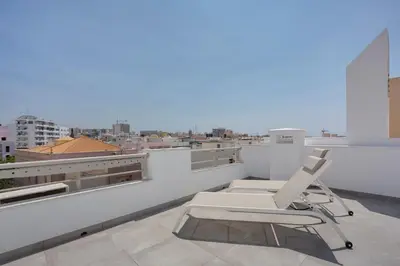 a white chair sitting on top of a roof at Hotel Made inn Faro in Faro