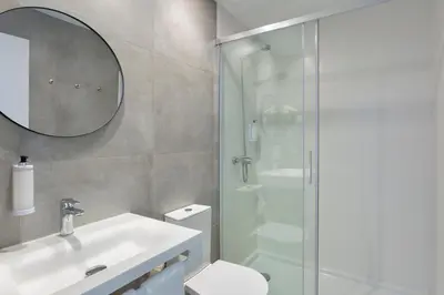 a bathroom with a shower and a sink and a toilet at Hotel Made inn Faro in Faro