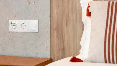 a bedroom with a bed and a light switch at Hotel Made inn Faro in Faro