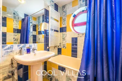 a bathroom with a sink and a blue shower curtain at Villa AcquaMarina - 5 bedroom, water front villa in Albufeira