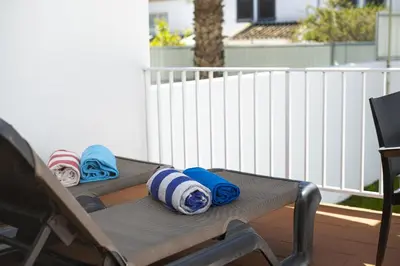 a bedroom with a bed and a chair and a window at Mouraliz Apartments by HD PROPERTIES - Vilamoura Marina in Vilamoura
