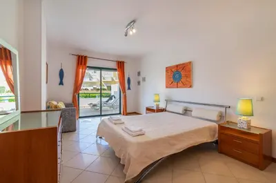 a bedroom with a large bed and a window at Jardins Santa Eulalia by Garvetur in Albufeira